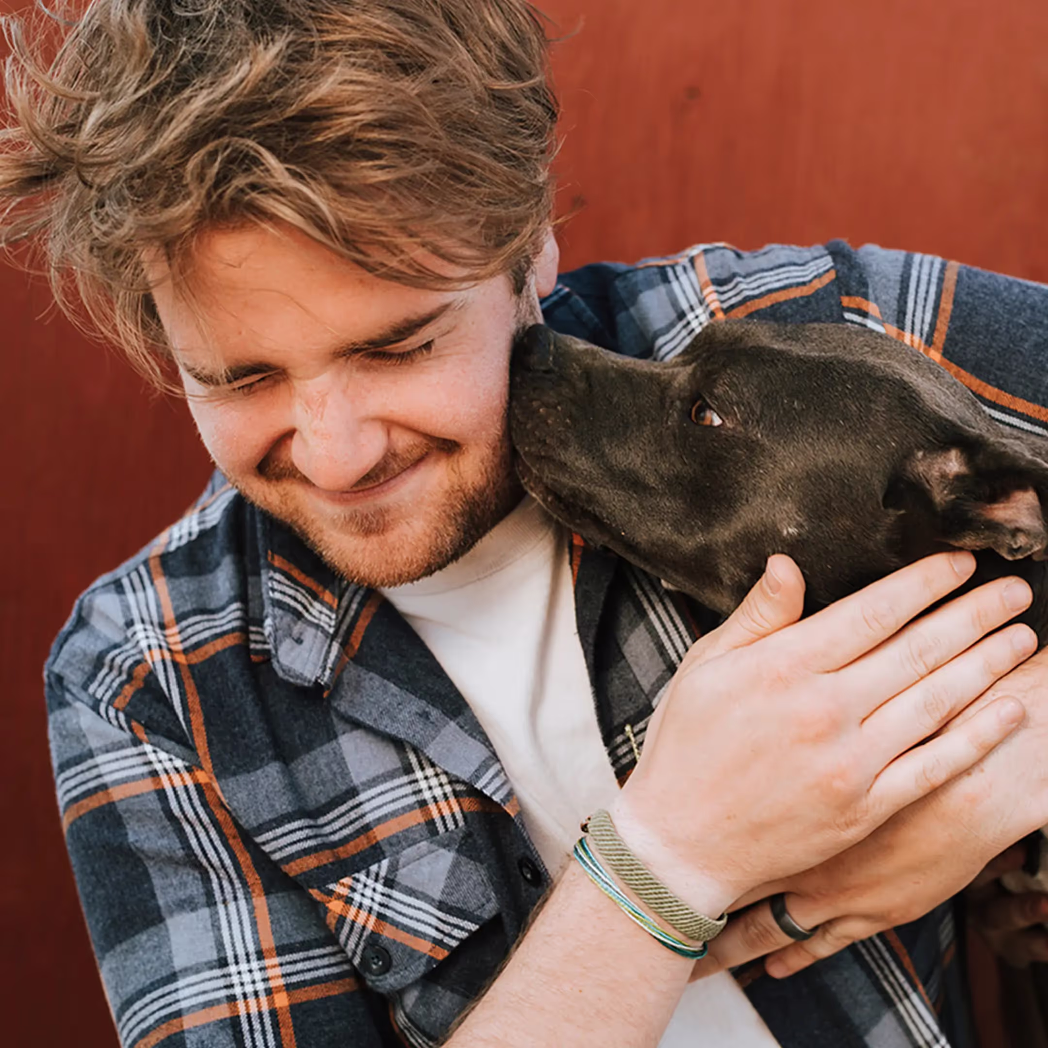 A man embraces a dog, showing affection and warmth in their bond.